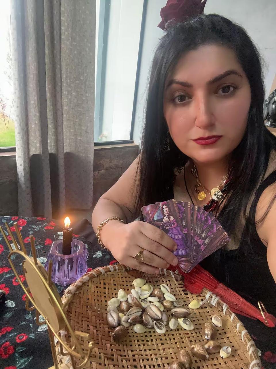Bruxa Catarina em seu espaço de atendimento com cartas, ervas e velas